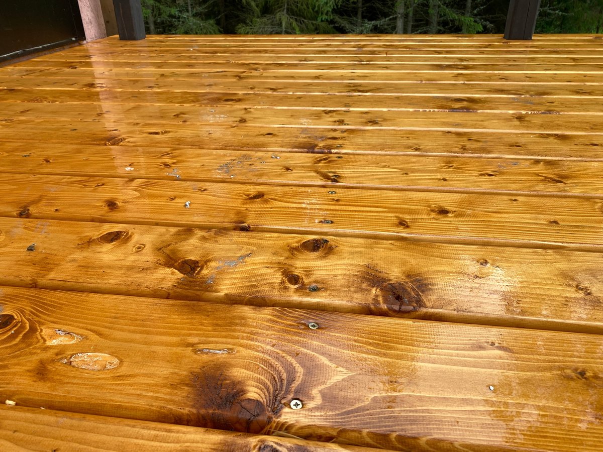 New cedar deck boards laid across a terrace surrounded by woodland